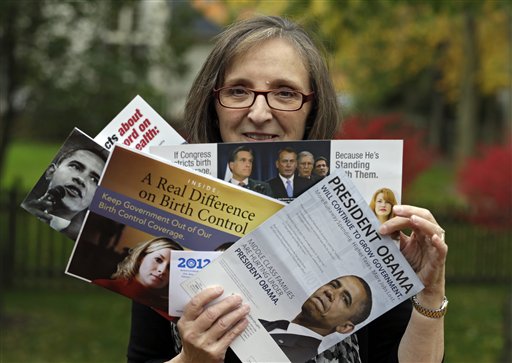 Jean Gianfagna displays some of the political mailers her family receives at her home in Westlake, Ohio. Gianfagna says her family is “deluged” and sometimes gets four of the same piece at a time – her husband and two grown kids all get their own. Voters in battleground states have been inundated by mailers, calls and visits to their homes.