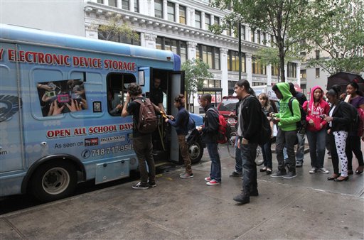 Students from New York's Washington Irving educational complex line up last week to leave their cellphones and other electronic devices, for a dollar a day per item, in a privately operated truck parked near their school.