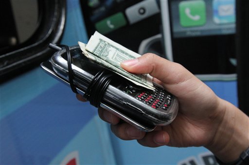 A student hands over two electronic devices and payment of a dollar for each at the Pure Loyalty Electronic Device Storage truck parked near the Washington Irving educational complex in New York.