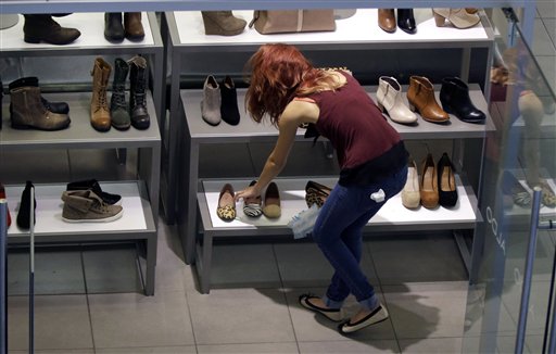 A clerk straightens up at a shoe store in Salem, N.H. Americans increased spending last month.