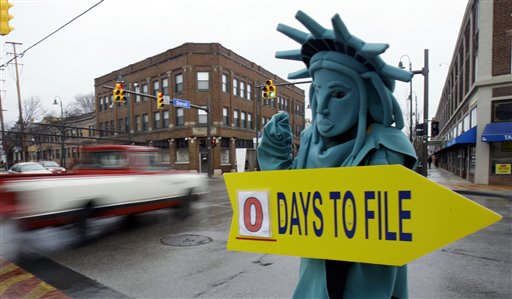 Max Martinez, dressed as the Statue of Liberty, tries to alert motorists on the final day to file taxes in this 2011 photo. A typical middle-income family making $40,000 to $64,000 a year could see its taxes go up by $2,000 in 2013 if lawmakers fail to renew a lengthy roster of tax cuts set to expire at the end of 2012, according to a new report.