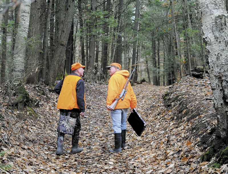 Bill Moulton, right, of Pittston, chats with his pal, Gary Alexander, of Gardiner, as they walk down a path in a wood in South Gardiner in pursuit of whitetail deer last season. Moulton said the men have been hunting together "for about 68 years."