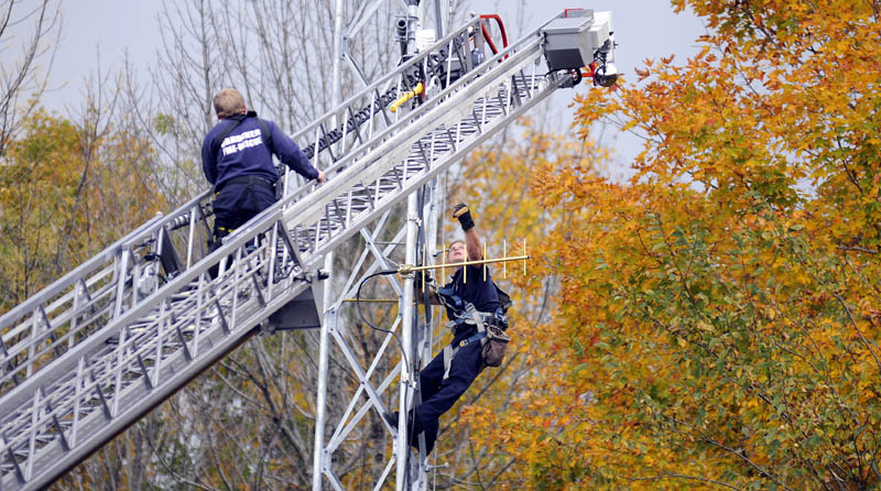 Staff photo by Andy Molloy TUNING IN: Gardiner firefighters Rick Seiberg, right, and Josh Johnson hang communication devices on the City of Gardiner's new public safety antenna Tuesday at city hall.