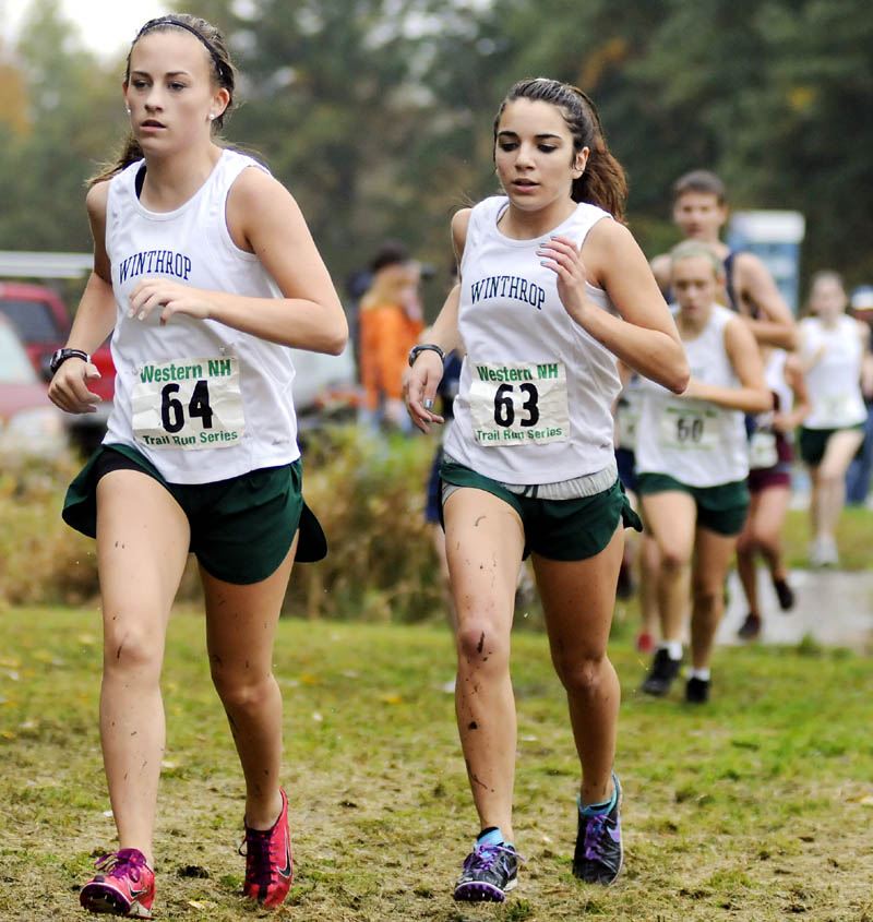 RUNNING IN A PACK: Winthrop High School’s Molly Kieltyka, left, and teammate Kaitlin Souza compete on a muddy course Wednesday during a cross country meet at Monmouth Academy.