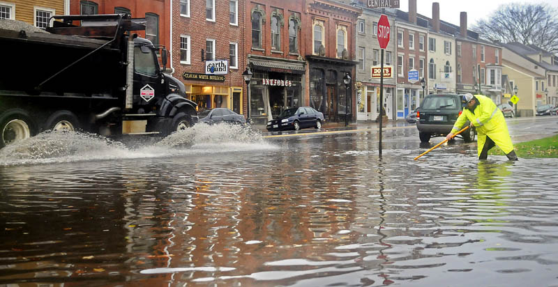 Hallowell public works employee Chris Buck clears a flooded storm drain Tuesday at the intersection of Central and Water Streets. Leaves displaced by superstorm Sandy plugged gutters and drains across Maine.