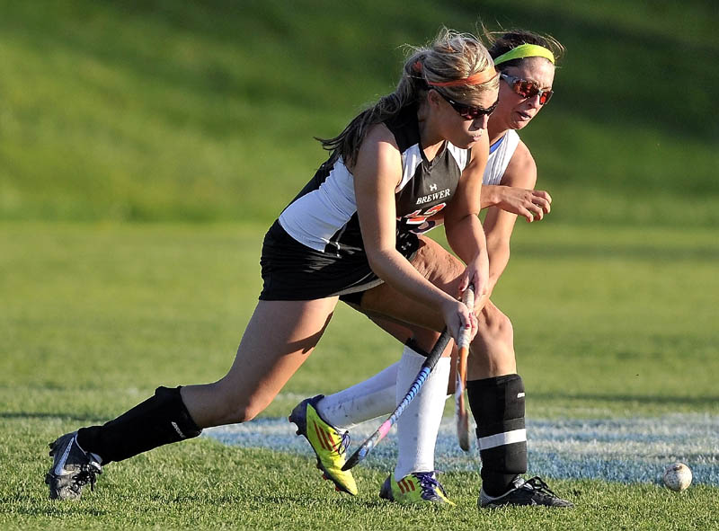 Staff photo by Michael G. Seamans Lawrence High School's Kaprice Dahms, 5, back, fights for the ball with Brewer High School's Rachel Triplett, 12, in the second half of an Eastern A quarterfinals game at Lawrence High School in Fairfield Thursday. Lawrence defeated Brewer 2-1.