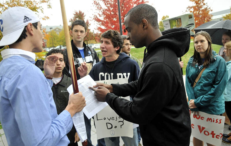 DEMONSTRATION: Colby College students Shelby O'Neill, center, and Uzoma Orchingwa, right, clash with fellow student Steve Carroll, left, outside the Diamond Building at the college during a protest against Bob Diamond protest organized by Occupy Augusta and concerned Colby College students on Saturday.