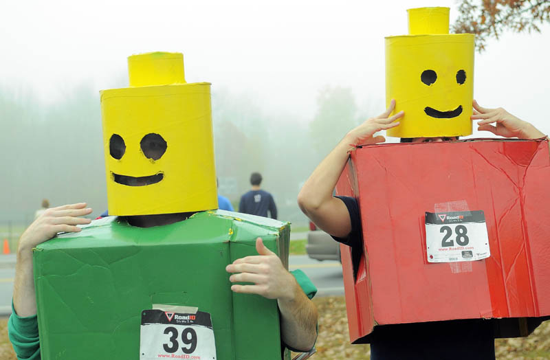 Colby College students Ben Chwick, left, and Brendon Bourgea, right, get in to their Lego costumes for the 4th annual Freaky 5k Run and Walk hosted by Hardy Girls Healthy Women and Colby Volunteer Center at Colby College Saturday morning.
