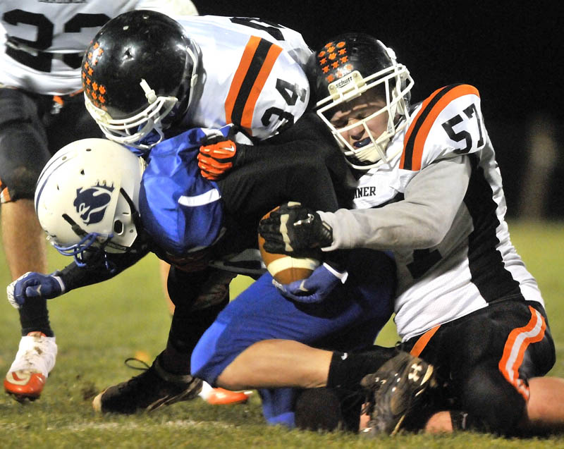 Staff photo by Michael G. Seamans Gardiner High School's Jory Vermillion, 57, right, and teammate seth Wing, 34, top, tackle Madison High School's Paul Dawe, 36, in the first half in Madison friday night.