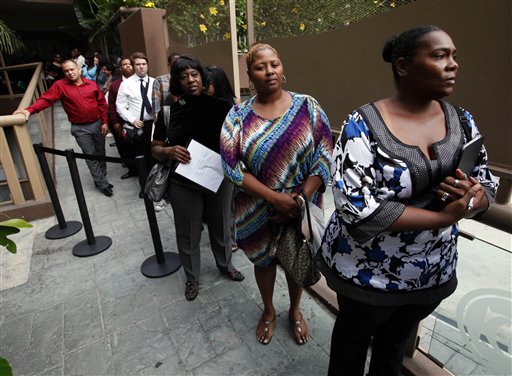 In this Aug. 17, 2012, photo, Sheila Bird, right, waits in line for employment interviews at a job fair at City Target in Los Angeles.