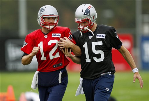 New England Patriots quarterback Ryan Mallett (15) tries to pull the ball from starting quarterback Tom Brady's arm as they run next to each other during a drill at practice at the NFL football team's facility in Foxborough, Mass., Wednesday, Oct. 10, 2012. (AP Photo/Stephan Savoia)