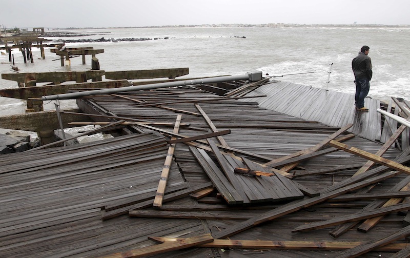 Nicholas Rodriguez looks over a section of the destroyed boardwalk in Atlantic City, N.J., Tuesday, Oct. 30, 2012, not far from where a powerful storm that started out as Hurricane Sandy made landfall the night before. Millions of people from Maine to the Carolinas awoke Tuesday without electricity, but the full extent of the damage in New Jersey, where the storm roared ashore Monday night with hurricane force, was unclear. (AP Photo/Seth Wenig)