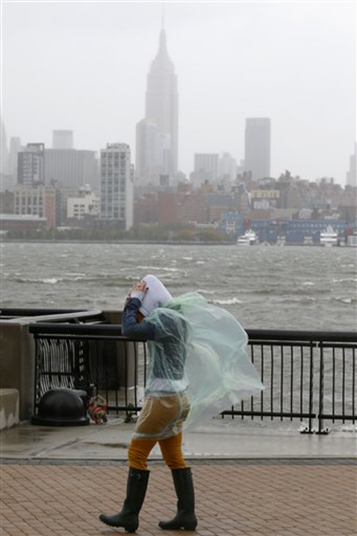 Heather Maschi, 24, tries to keep her hood on as gusty winds blow near the Hudson River on Monday in Hoboken, N.J.