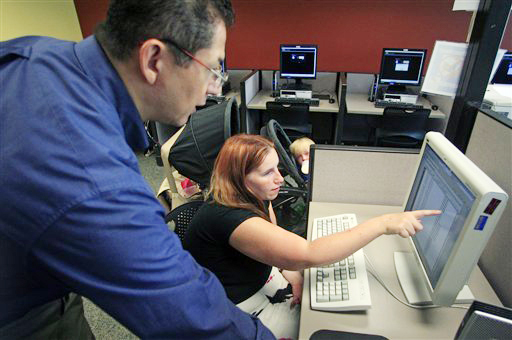Deanna Aguilera, 30, of Salt Lake City, right, receives assistance from employment counselor Frank Trivino while job searching recently at Workforce Services in Salt Lake City.