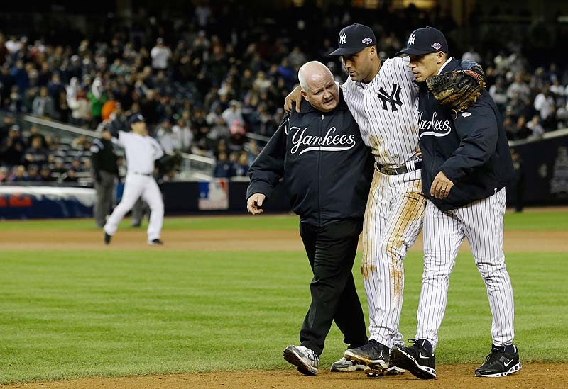 Trainer Steve Donohue, left, and Yankees Manager Joe Girardi help Derek Jeter off the field after he injured himself during Game 1 of the ALCS Saturday night against the Detroit Tigers. Jeter broke his ankle fielding a grounder in the 12th inning and is done for the postseason.
