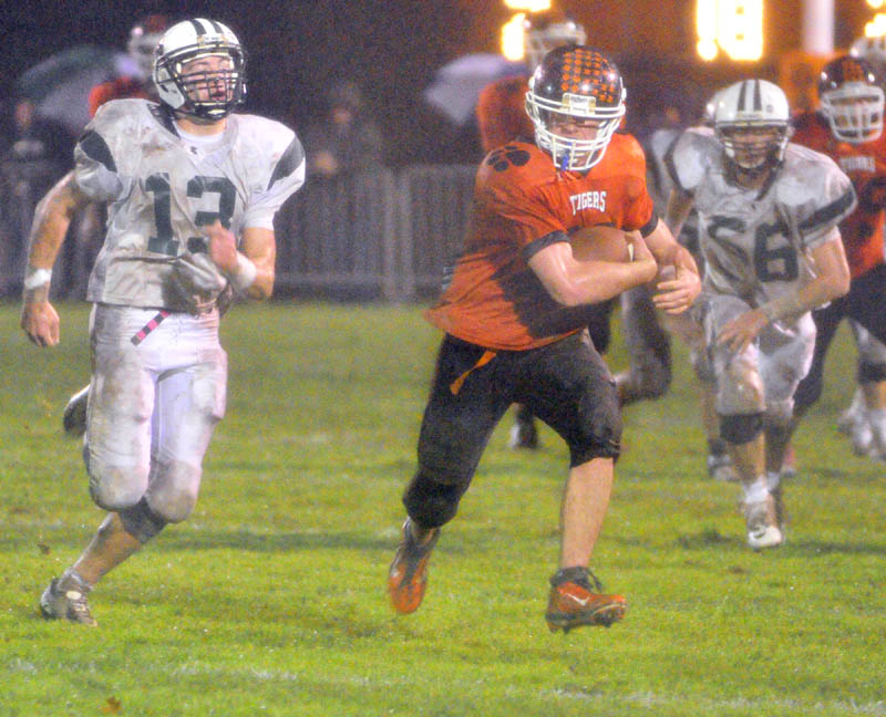 GAINING GROUND: Gardiner running back Steve Sirois, center, tries to outrun Leavitt defensive back Brian Bedard, left, and defensive end Brandon Collins during a game Friday at Hoch Field in Gardiner.