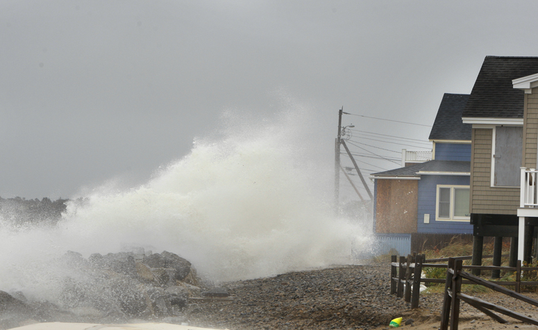 A wave comes over a sea wall in Saco near houses on Eagle Avenue during high tide on Monday. The surge from Hurricane Sandy caused some beach erosion in Saco and there was minor flooding in Camp Ellis.