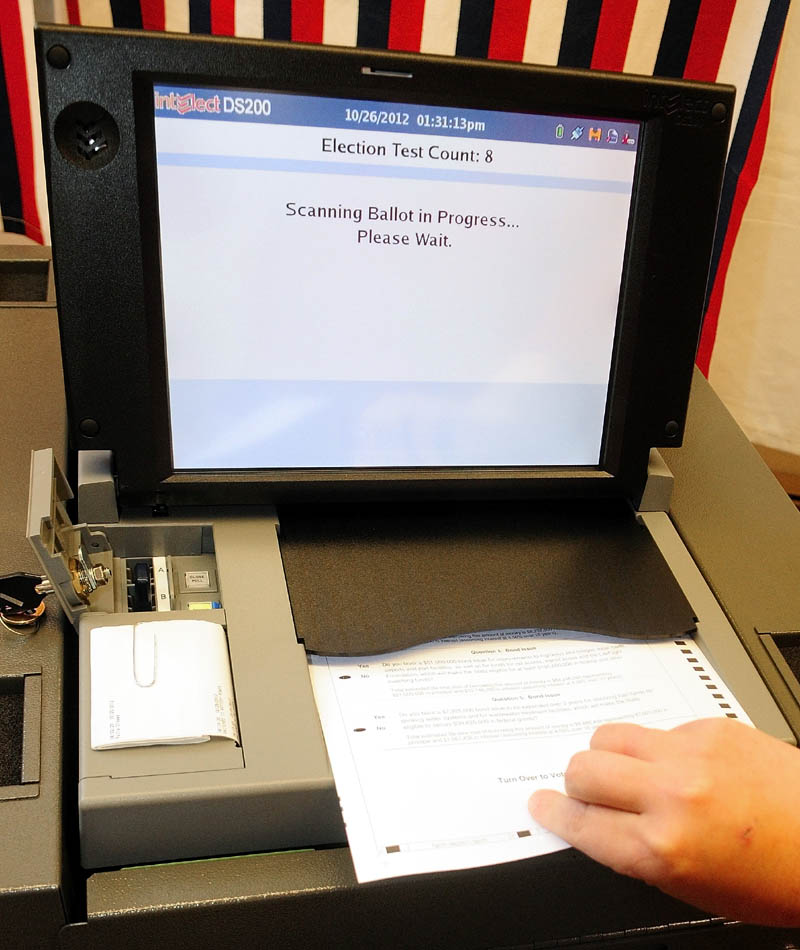 Town Clerk Lisa Gilliam runs a test on Chelsea's new IntElect DS200 electronic ballot-counting machine on Friday afternoon.