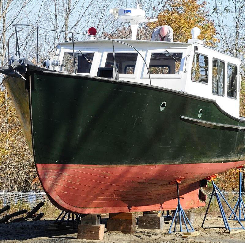 Jerry Maschino works on getting his boat Explorer ready for winter storage on Friday afternoon near his Gardiner. He said that she was built in Stonington in 1949 and had been moored over the summer in the nearby Kennebec River.