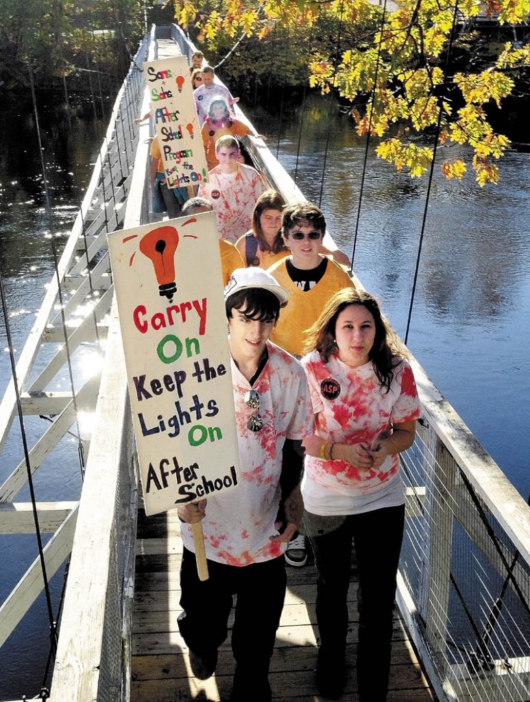 Staff photo by David Leaming Students and staff from Skowhegan High and Middle schools march across the walking bridge in town during a rally and support for the national 13th annual Lights On Afterschool program on Thursday.