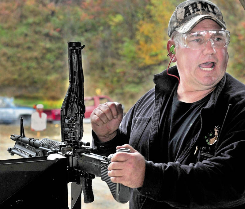 Andy Williams calls for more ammunition while reloading an automatic weapon during the Maine Wounded Warrior Shoot Out that his family hosted for injured veterans in Anson, on Sunday.