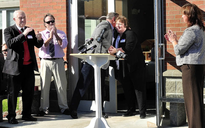 Gov. Paul LePage congratulates Mid-Maine Homeless Shelter Executive Director Betty Palmer as Doug Cutchin, left, Kevin Joseph and Susan Reisert applaud during the opening of the new shelter on Monday.