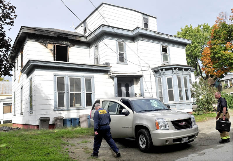 INVESTIGATION: Ken MacMaster, left, of the state Fire Marshal's Office, and Waterville firefighter John Gromek prepare to enter an apartment building in Watervile on Wednesday to determine the cause of a fire that damaged the building on Tuesday.