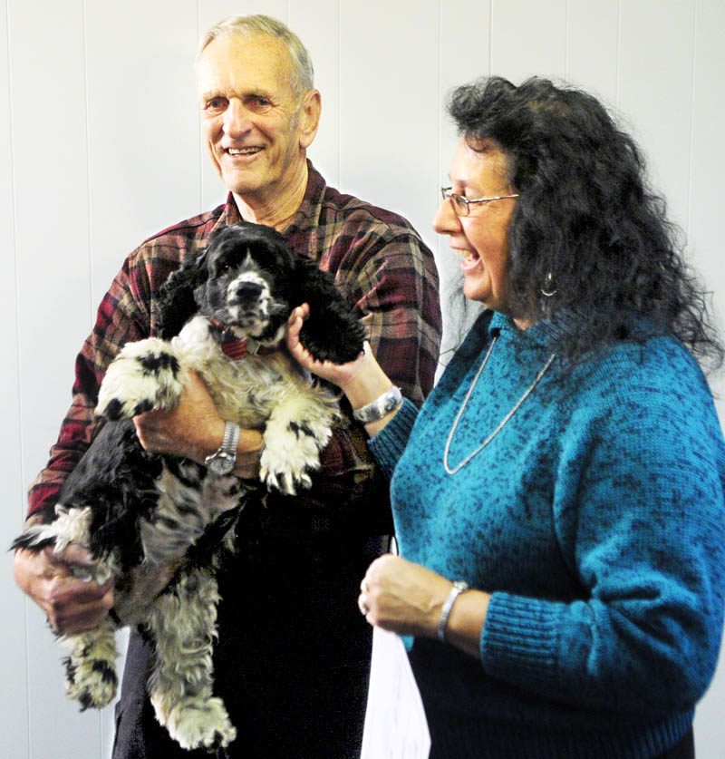 Lottery winner Linda Von Oesen, of Fairfield, right, and her husband Bob Von Oesen speak to reporters as they pet Abby, their three-year-old cocker spaniel during a news conference on this morning in Hallowell.