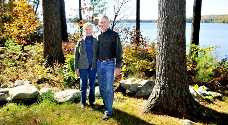 PROTECTORS: Phyllis and Lynn Matson stand beside a wooded buffer zone between their home and Long Pond in Rome. The buffer helps reduce erosion that contains phosphorus and other nutrients that can adversely affect the water. The Matsons received a LakeSmart award for their efforts.