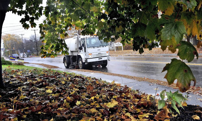 Tim Green of the Waterville Public Works department sweeps Upper Main Street clear of leaves and other small debris on Monday. The leaves could play a big part in flooding streets when hard wind and rain arrives for several days this week from Hurricane Sandy.