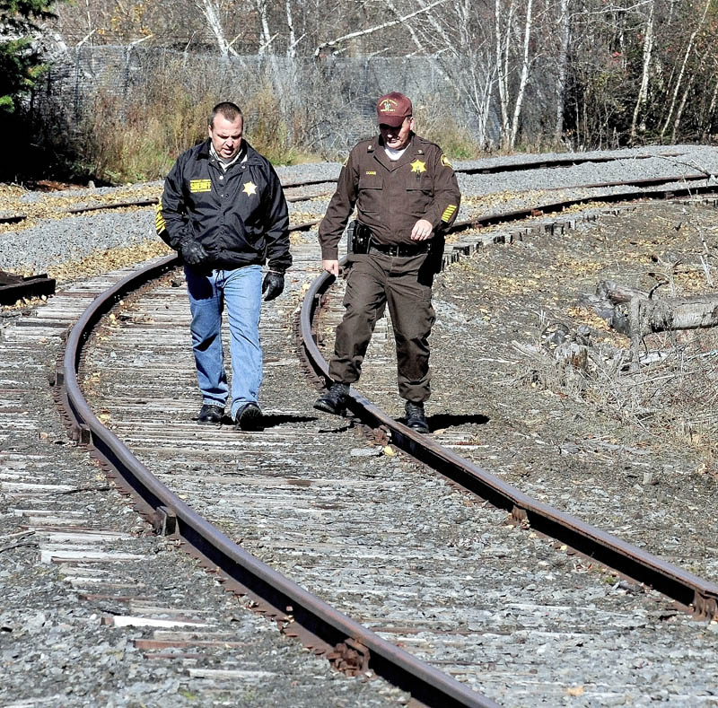 SEARCH: Somerset County Sheriff Deputies Bill Quigley, left, and Will Dodge walk along a railroad track between Union Street and the Carrabassett River in North Anson while searching for a weapon that may have been used by Randy Grover Jr. earlier in the day. Grover was arrested for domestic terrorizing.