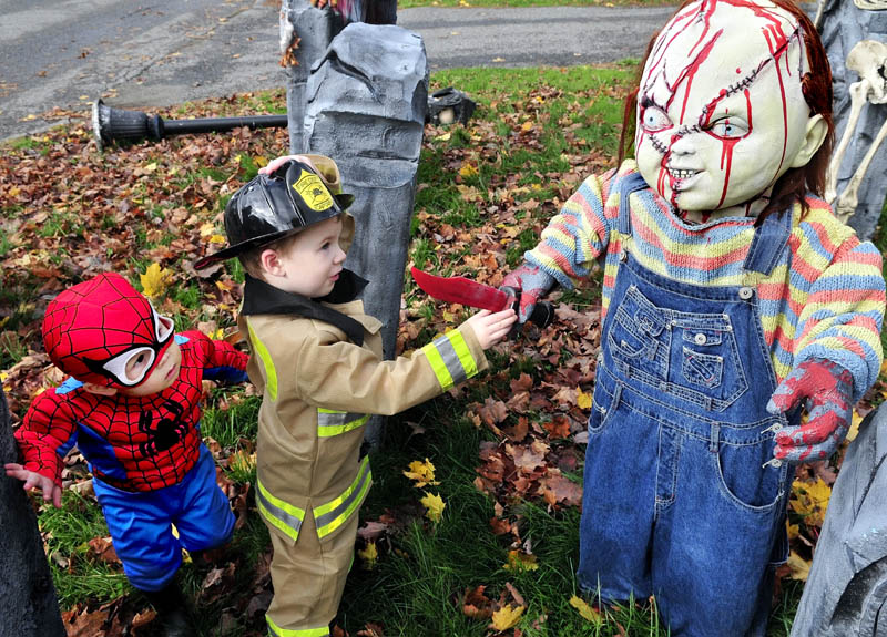 Ben Coles, left, and Glen Carol cautiously check out the "Chucky" character in the Halloween display at Melissa and Jeff Giguere's home in Waterville, on Wednesday. The kids were part of a large group from the Black Bear Nursery in Waterville.