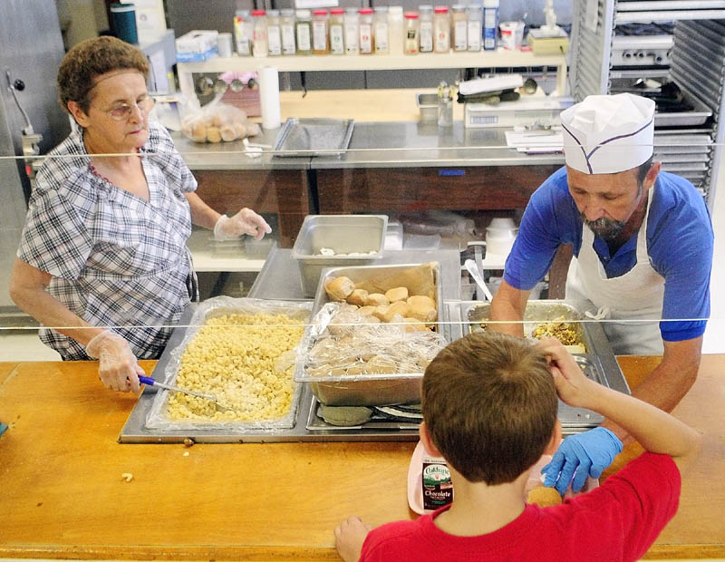 Sharon Nash, left, and Rick McArthur serve up hot lunch, either Shepherd's Pie or Mac & Cheese, to students last week at Pittston Consolidated School.
