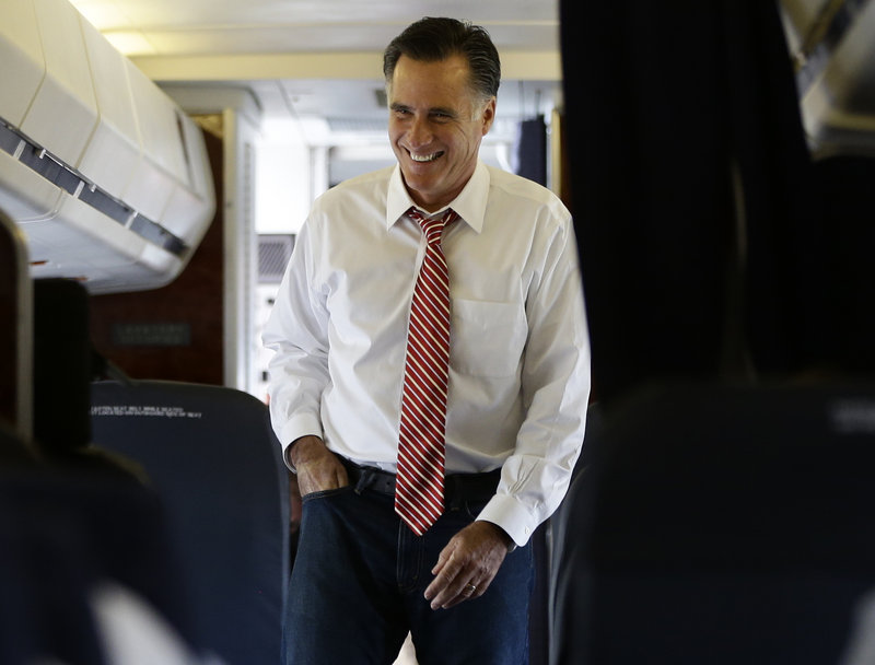 Republican presidential candidate Mitt Romney smiles as he speaks to advisers and staff members on his campaign plane in Denver on Thursday.
