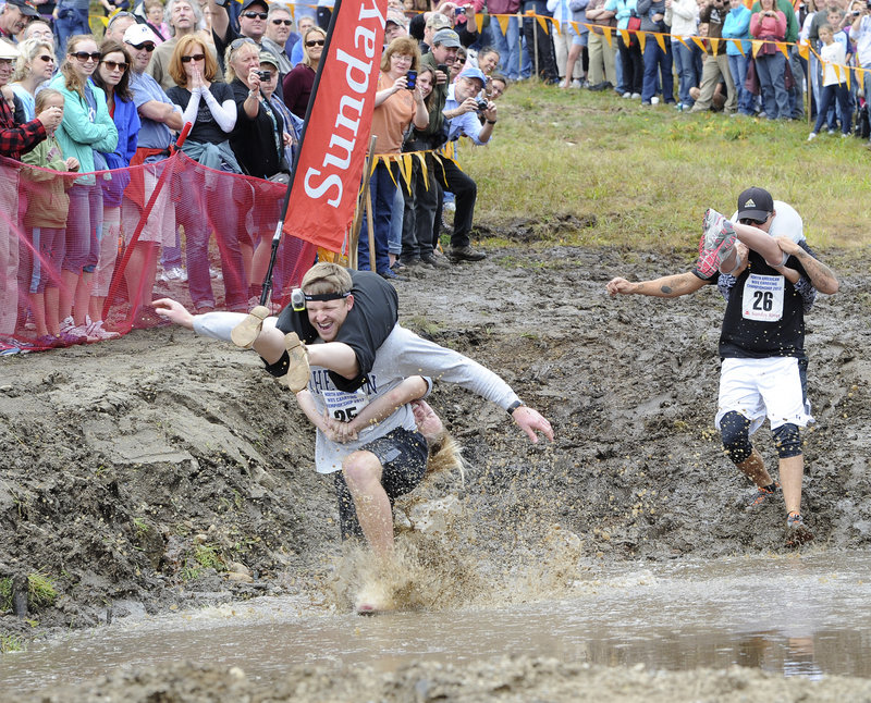 Miles and Kate Egbert of Michigan trudge through a muddy pond during the 2012 North American Wife Carrying Championship at Sunday River in Newry on Saturday. Fifty couples competed in the obstacle course.