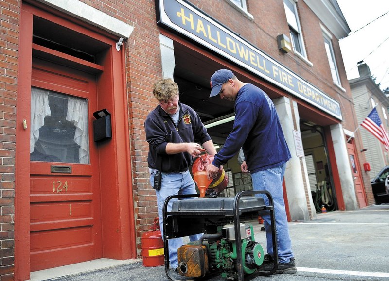 Hallowell firefighters Rick Seymour, left, and Roy Girard fuel up a generator Sunday at the town fire station. The volunteer company was testing emergency equipment and preparing the station for the arrival of storm Sandy, which may disrupt power and cause flooding.