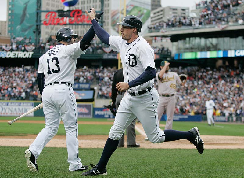 Don Kelly, right, is met at the dugout by Alex Avila after scoring on a wild pitch in the eighth inning for the Tigers in Game 2 of the American League division series on Sunday in Detroit. Kelly drove in the winning run in the ninth with a sacrifice fly to give Detroit a 2-0 series lead.