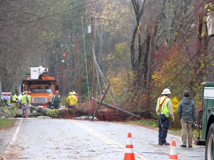 Crews from McDonough Electric Construction of Bedford, Mass., on Tuesday morning remove a cherry tree that had fallen over Princes Point Road near Gilman Road in Yarmouth. The tree was tangled in electrical lines.