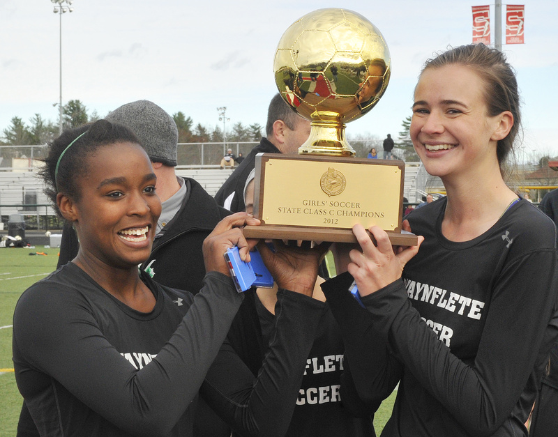 Waynflete captains Rhiannan Jackson, left, Katherine Harwood and Sadie Cole hold the girls' Class C soccer championship trophy following a 3-2 win over Fort Kent Saturday at Scarborough.