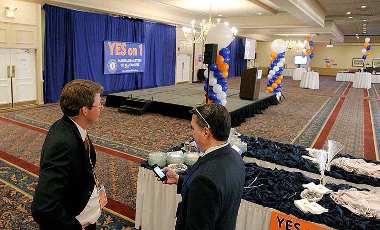 David Farmer and Miguel Rodriguez of Mainers United for Marriage talk in front of an empty stage on Tuesday at Holiday Inn by the Bay, where an estimated 1,000 supporters were expected to gather for an election night celebration.