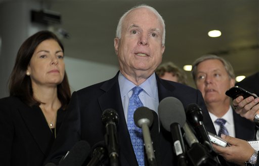 Sen. John McCain, R-Ariz., ranking Republican on the Senate Armed Services Committee, center, flanked by fellow committee members, Sen. Kelly Ayotte, R-N.H., left, and Sen. Lindsey Graham, R-S.C., right, speaks on Capitol Hill on Tuesday following a meeting with UN Ambassador Susan Rice.