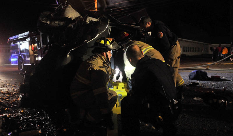 Delta Ambulance paramedics, Waterville police officers and the Waterville Fire Department work to extract at least two people from a Jeep that struck a treee off College Avenue in Waterville on Thursday night.