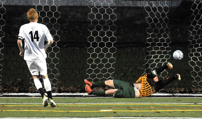 GAME-WINNER: Hall-Dale High School’s Colin Lush (14) scores the game-winning goal in a penalty kick shootout past Waynflete goalie Zander Majercik during the Western Maine Class C boys soccer championship game Thursday at Thomas College in Waterville. Hall-Dale won the shootout 5-4 and the game 1-0.