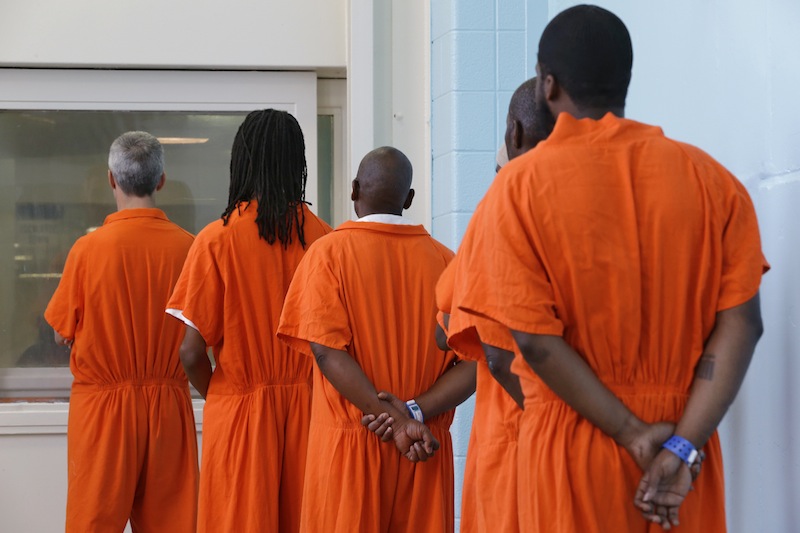 In this photo taken Oct. 24, 2012, prisoners line up to vote at the D.C. Jail in Washington. The voters at this southeast Washington polling place were all dressed alike: orange jumpsuit, white shoes. And when they finished voting they went back to their cell block, not back to work. Still, voting inside the D.C. Jail looked a lot like voting at precincts around the country. (AP Photo/Jacquelyn Martin)