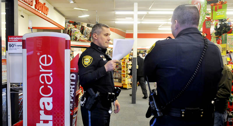 Augusta police confer Wednesday inside the CVS pharmacy on Capitol Street in Augusta, after a narcotics robbery.