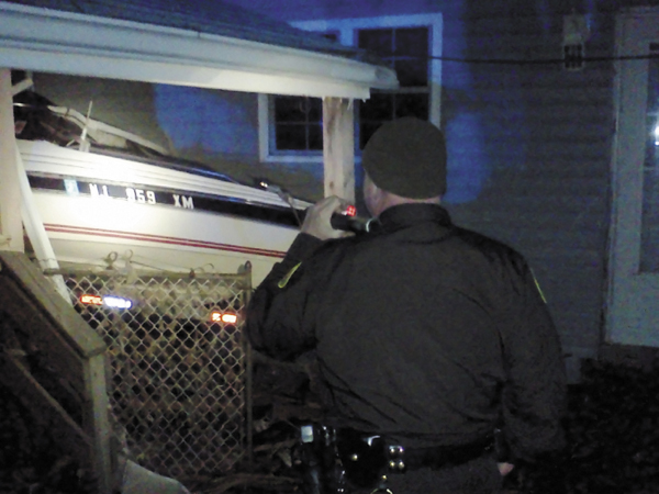 Cumberland County sheriff's Sgt. James Ambrose inspects a boat in Monmouth County, N.J., that was washed onto a house porch by Superstorm Sandy. Ambrose and contingent of Maine troopers and deputies are helping local police there patrol the streets and enforce a 6 p.m. to 6 a.m. curfew.