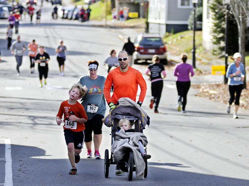 Hall-Dale Elementary students, parents, faculty and staff run down Second Street in Hallowell on Sunday during the inaugural Sugar Rush 5K. The parent-teacher organization hosted the walk and jog to raise funds for the school and donate extra Halloween candy to Operation Gratitude, which delivers sweets to troops serving abroad.