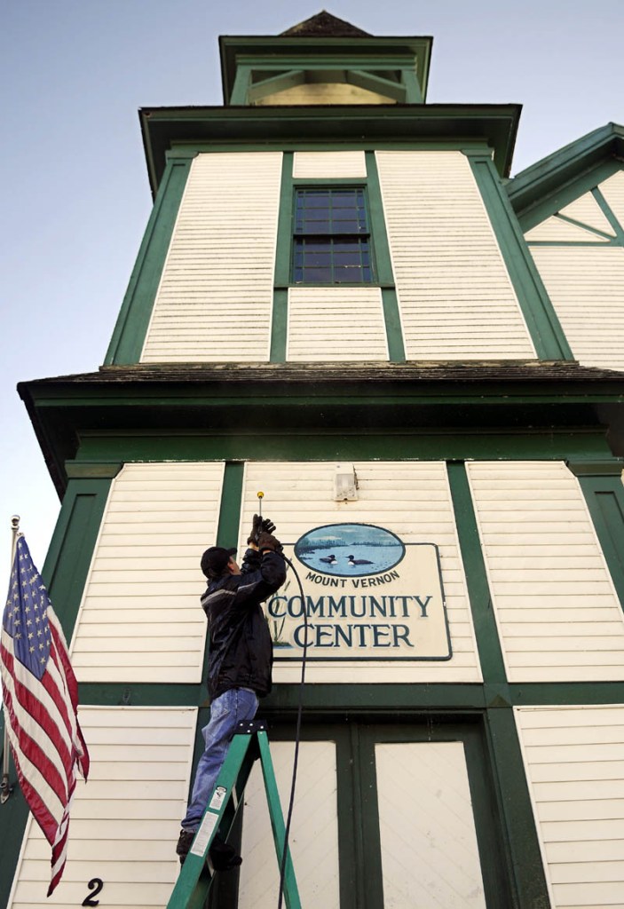 Darrell Trask, of Vienna, sprays the exterior Wednesday of the Mount Vernon Community Center, on the shores of Minnehonk Lake. The proprietor of Sunny Day Cleaning said he was soaked from pressure washing the first level of the decommissioned church which is open for town events. "I'm hurrying up because I'm freezing," Trask said.