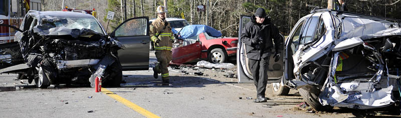Augusta Fire Chief Roger Audette, left, and Kennebec County Sheriff's Sgt. Mike Pion move among the wreckage of three vehicles that collided Thursday morning on Route 17 in Windsor, claiming the life of one man and injuring four people.