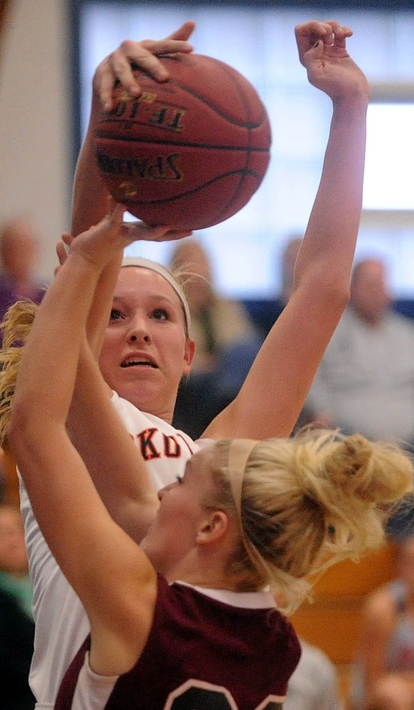 Staff photo by Michael G. Seamans Skowhegan High School's Morgan Buker, 32, rejects a shot by Nokomis High School's Lindsay Whitney, 22, in the first half of girls basketball action in the Bulldog Classic at Lawrence High School in Fairfield Saturday.